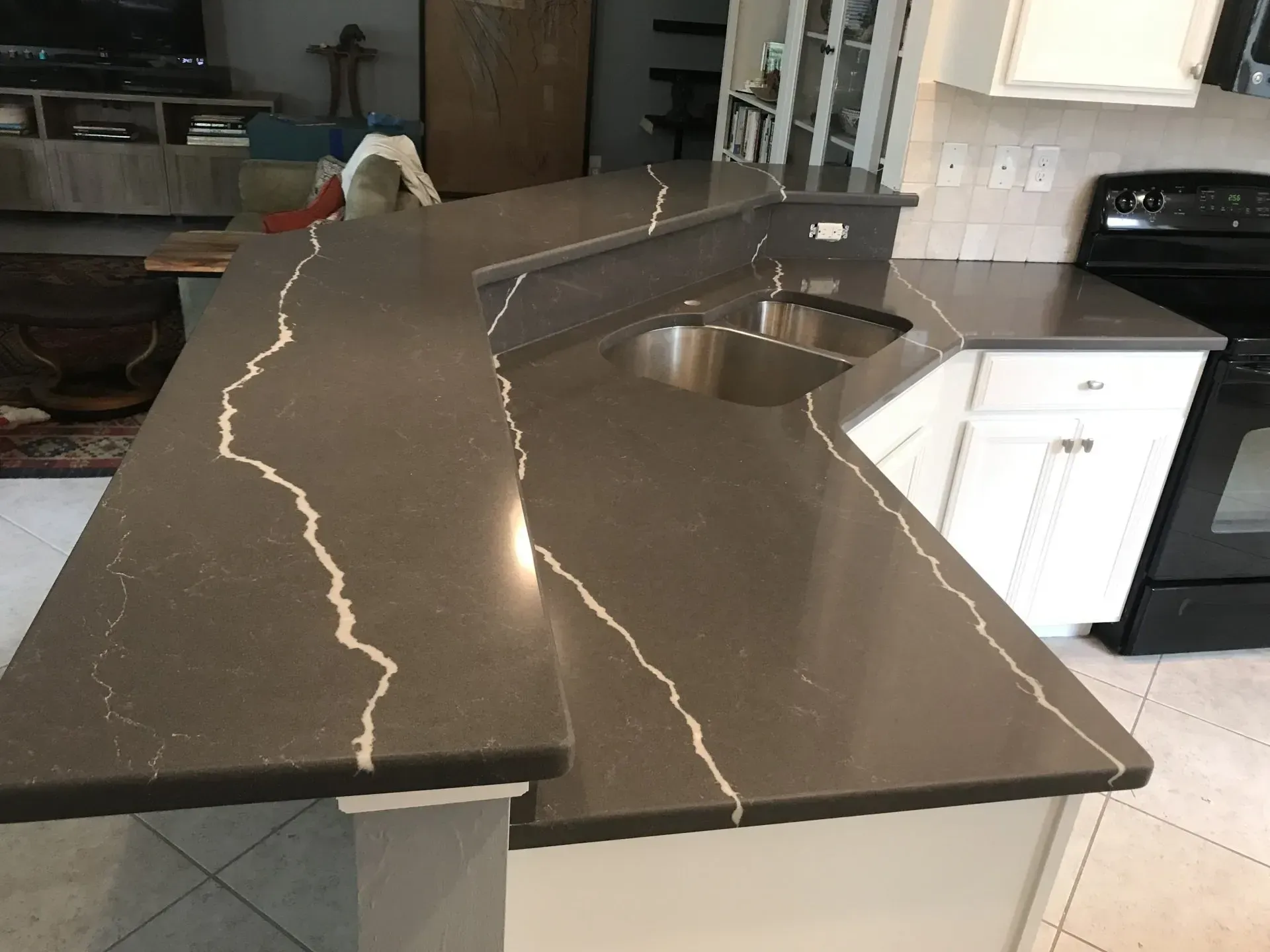 Black stone kitchen island countertop with built-in sink and white veining in a modern kitchen