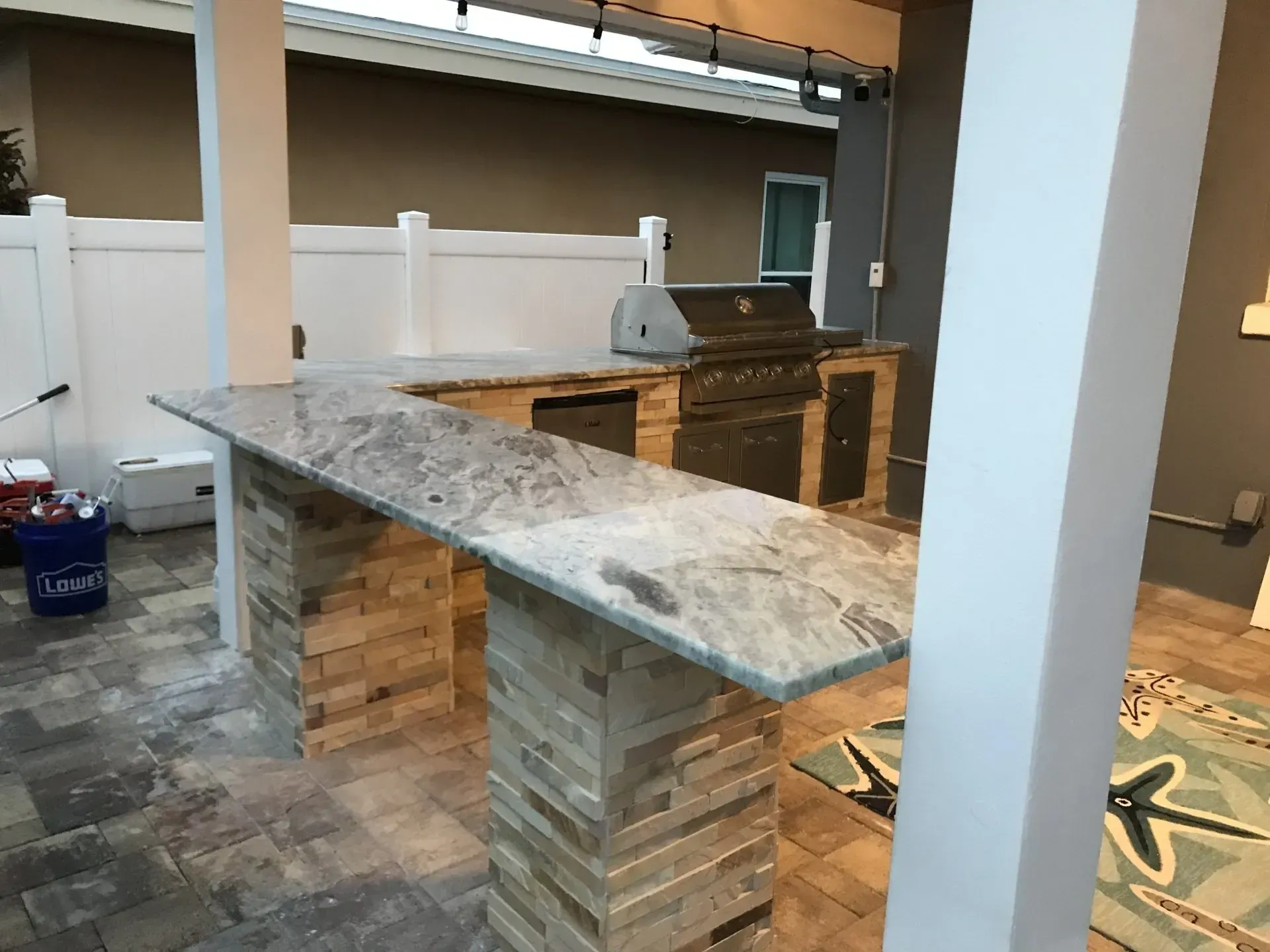 Unfinished kitchen island with stone countertop and stacked-stone base in a modern interior