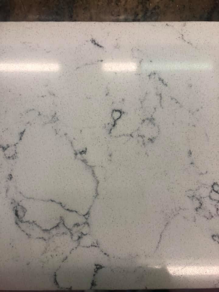 White marble countertop with gray veining and a glossy finish
