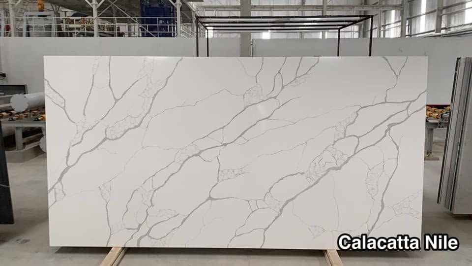Large white Calacatta marble slab with gray veining in an industrial workshop