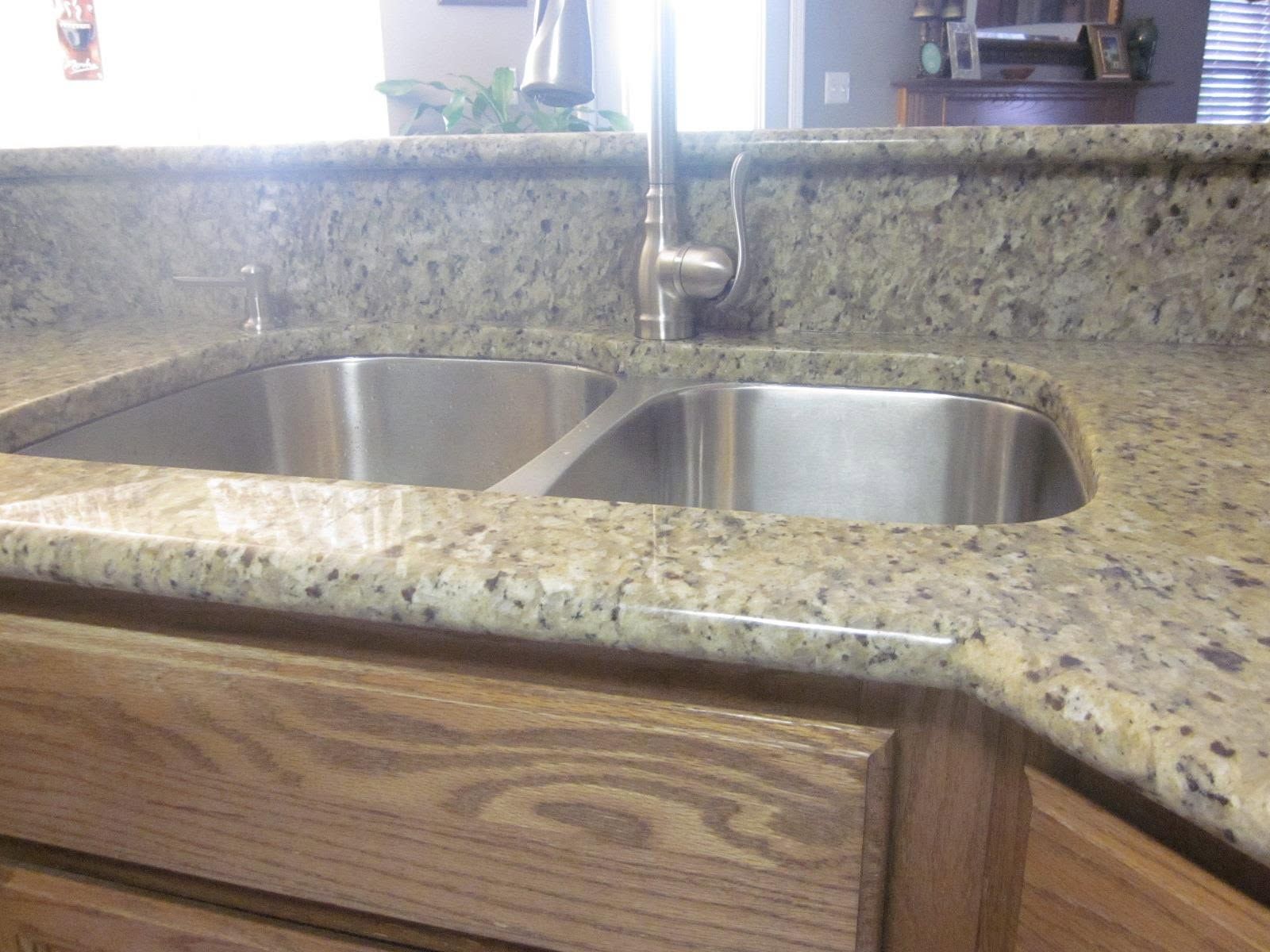 Granite kitchen countertop with double stainless-steel sink and wooden cabinet front