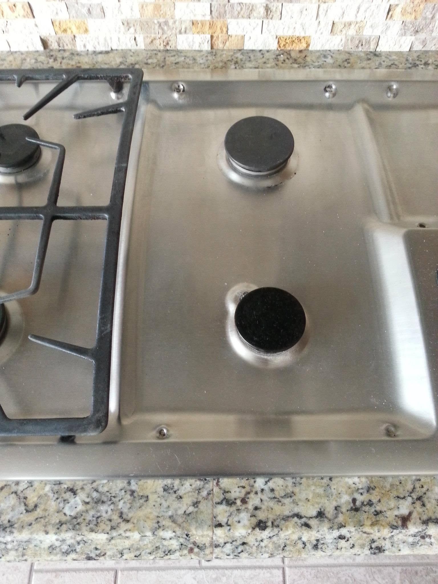 Stainless steel stovetop with two burners and a black circular cap on the right side.