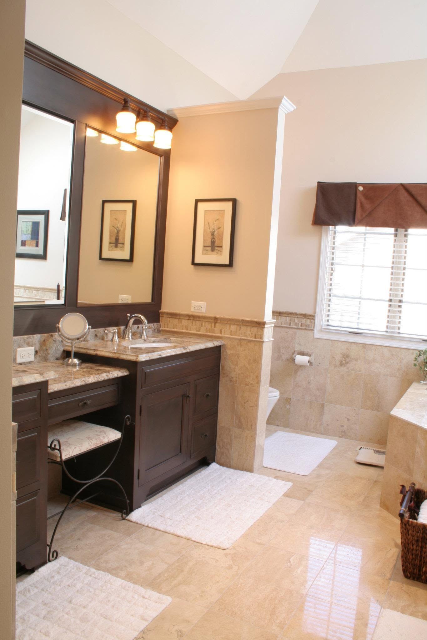 Bathroom with dark wood vanity, granite countertop, mirror, tiled walls, and window with blinds.