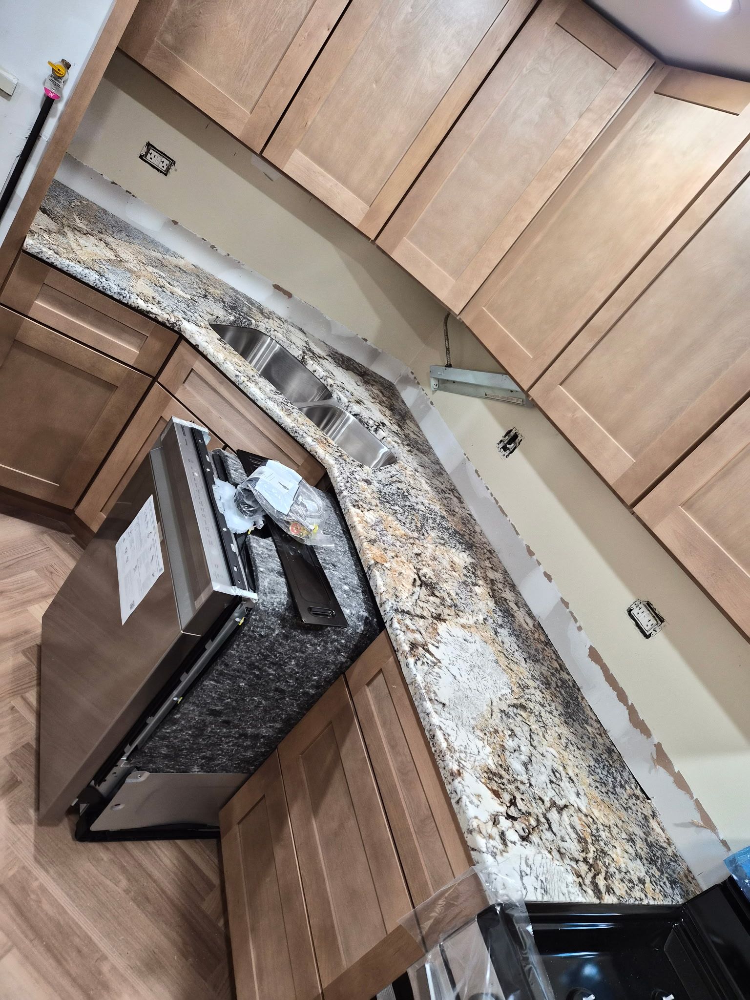 Kitchen with wooden cabinets, granite countertops, and a dishwasher drawer left open.