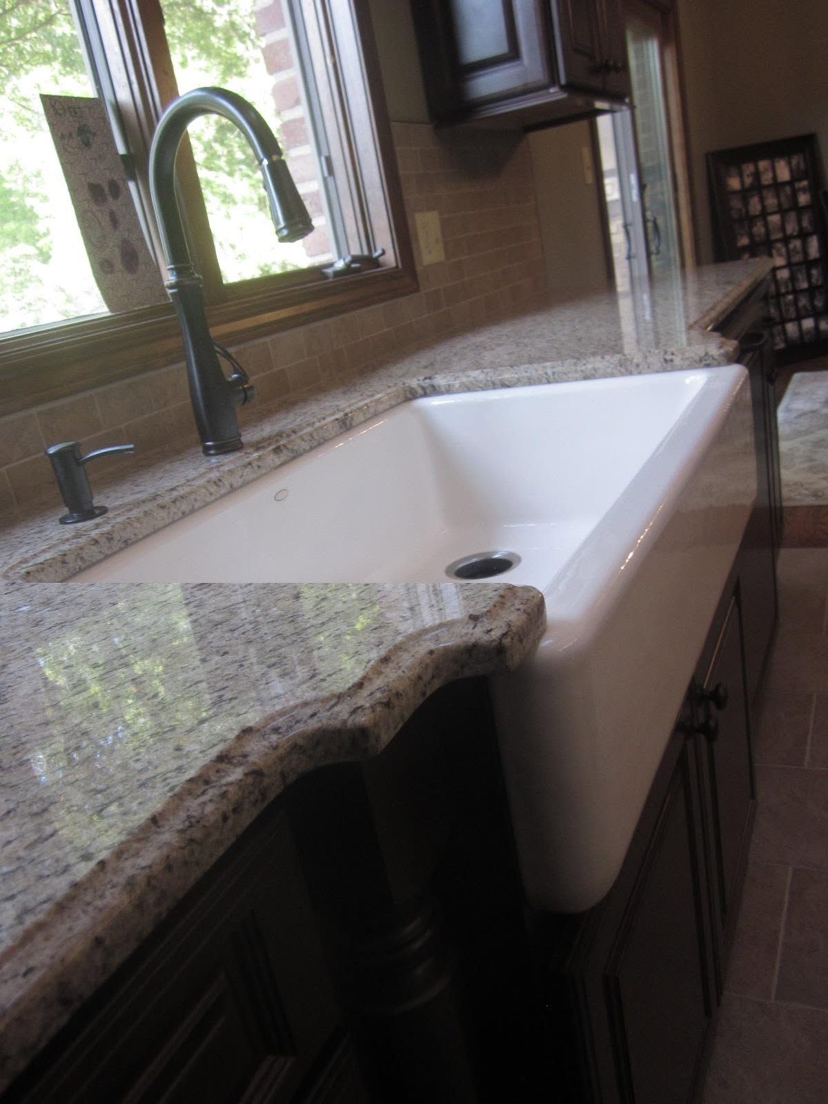 Kitchen sink beside granite countertop and black faucet in a bright modern kitchen