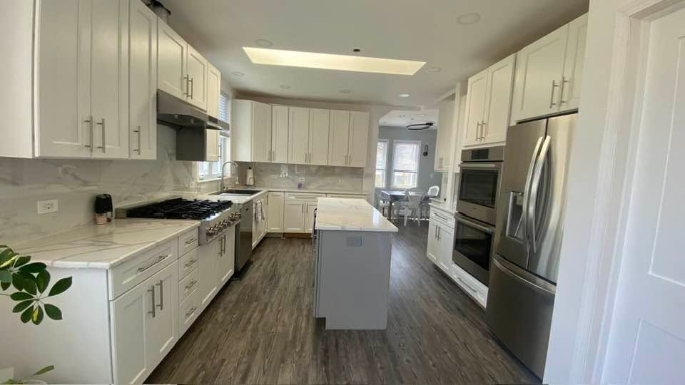 Bright modern white kitchen with stainless steel appliances and central island