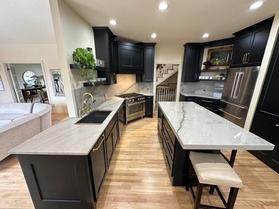 Modern kitchen with dark cabinets, white countertops, wood floors, and a central island with seating