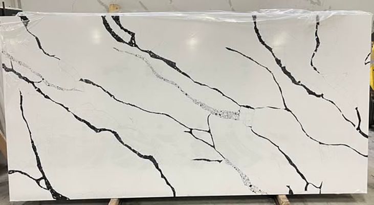 White marble-look rectangular slab with black veining and a thin beige strip along the bottom.