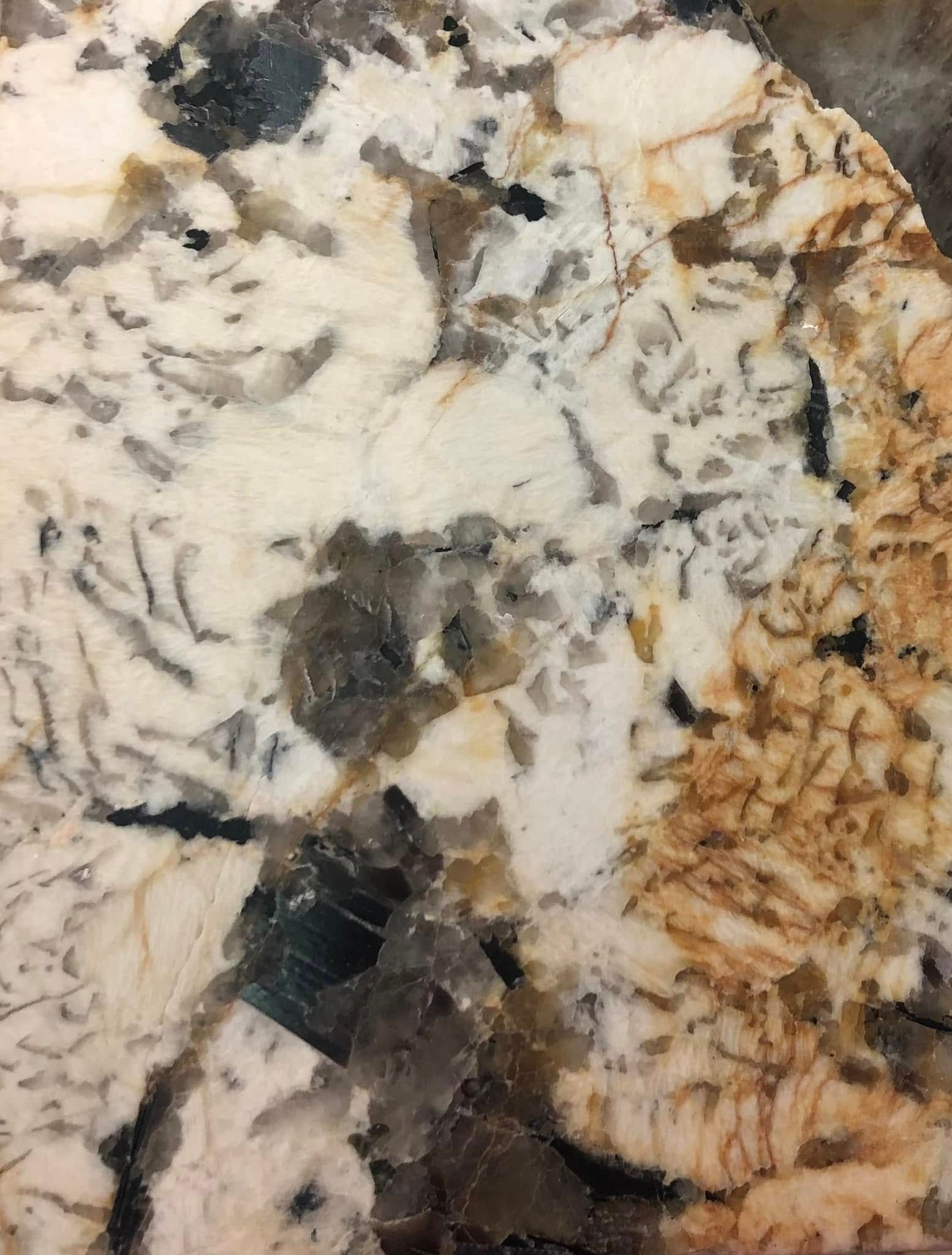 Close-up of a speckled granite surface with white, black, gray, and tan swirls