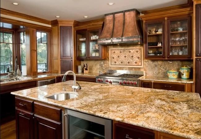 Luxurious kitchen with granite island, wood cabinets, stainless range, and large windows