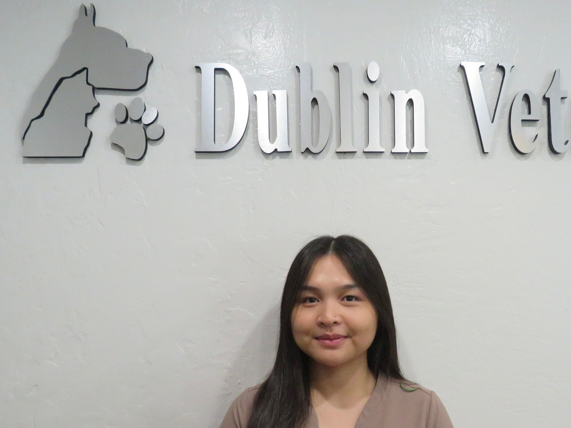 A woman stands in front of a dublin vet sign