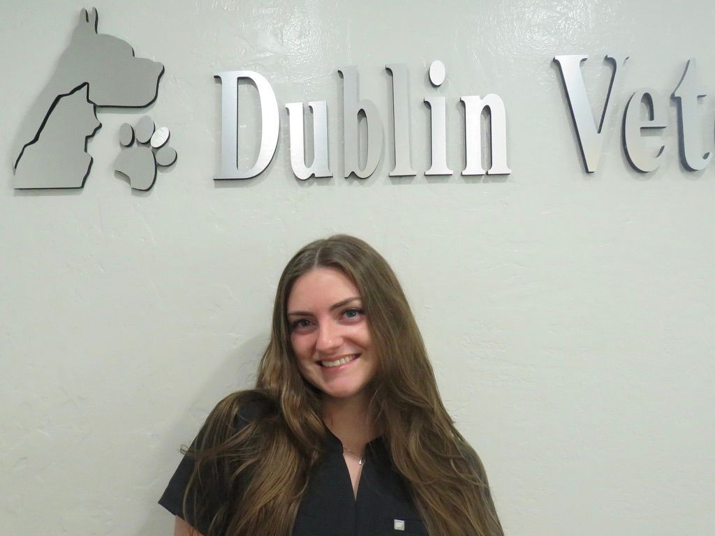 A woman stands in front of a dublin vet sign