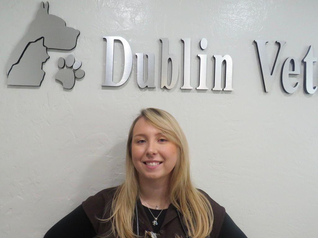 A woman stands in front of a dublin vet sign