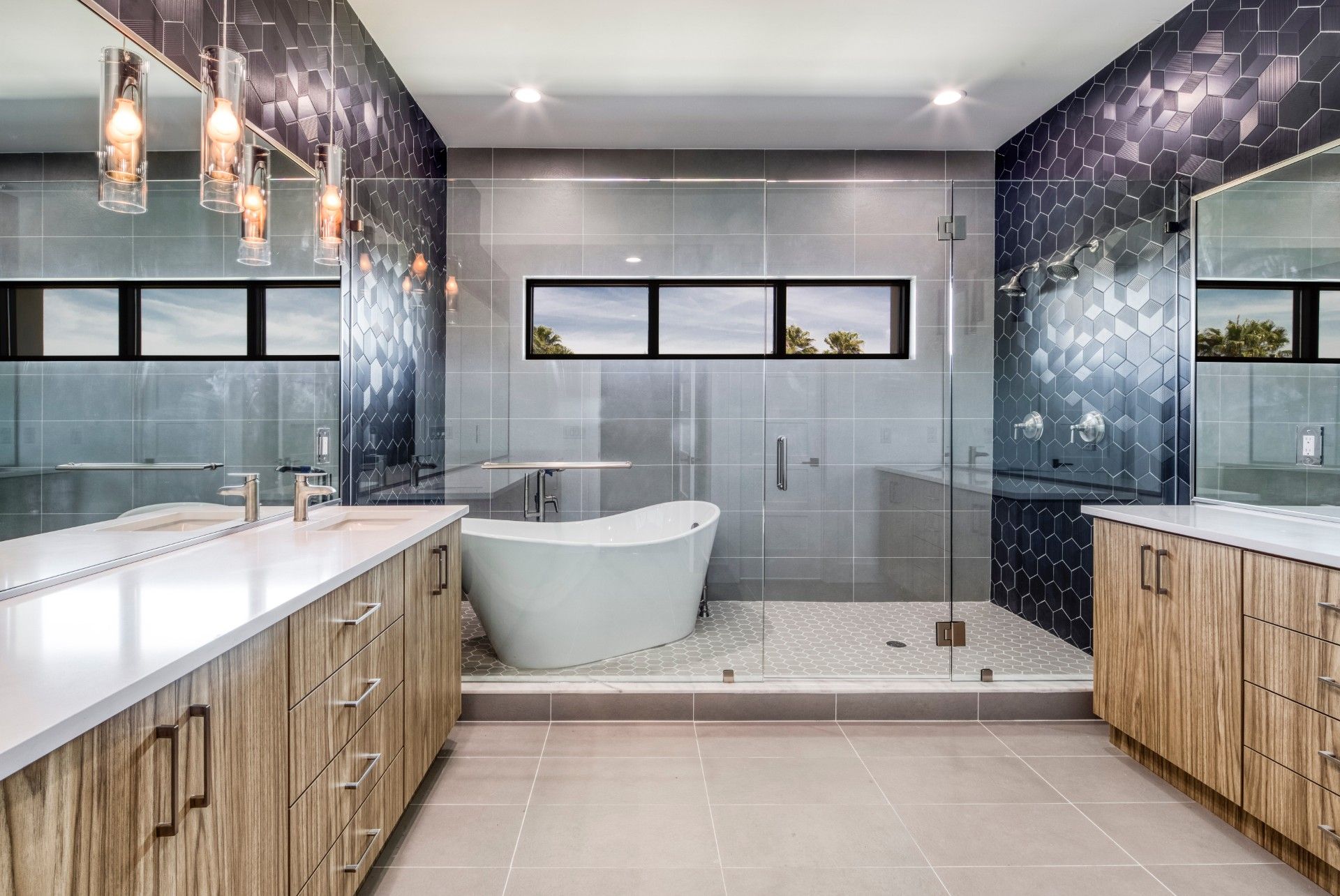 Modern luxury bathroom with double vanity, freestanding tub, glass shower, and marble tile.