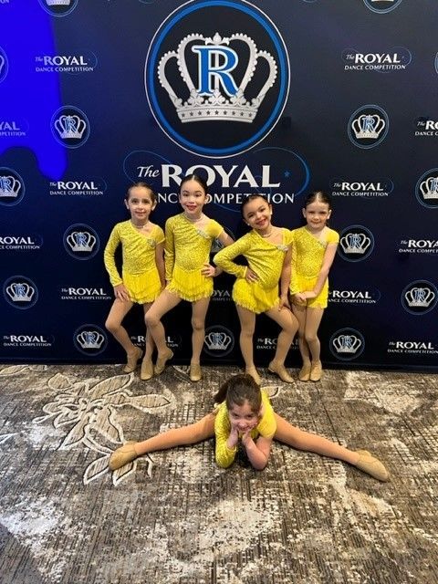 Five young girls in yellow dance outfits