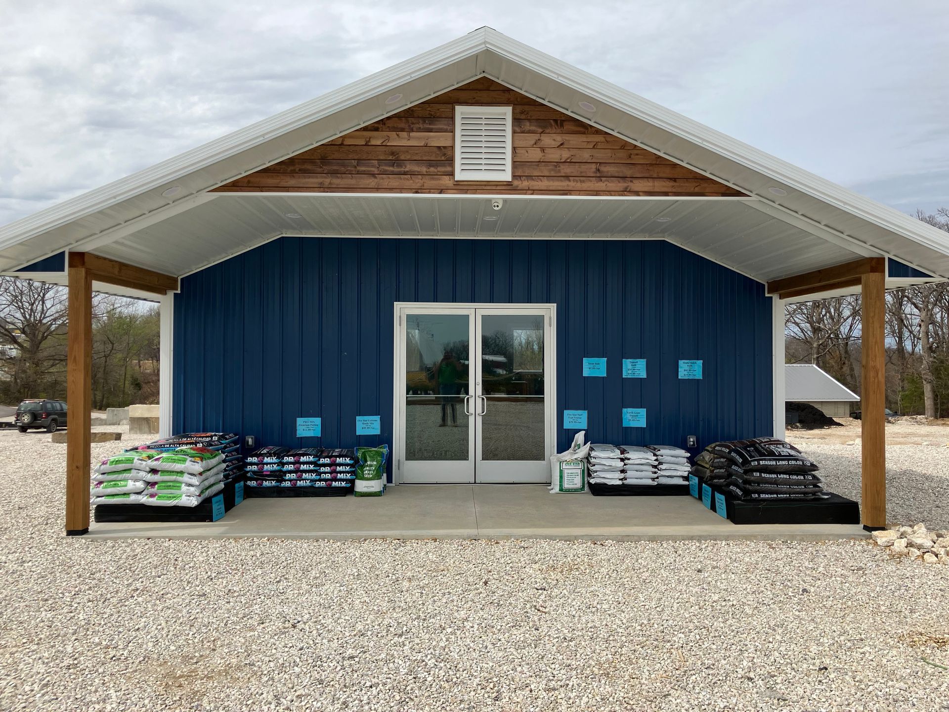 A blue building with a white roof and a porch.