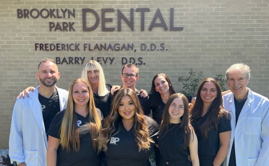 Brooklyn Park Dental staff smiling in front of building.