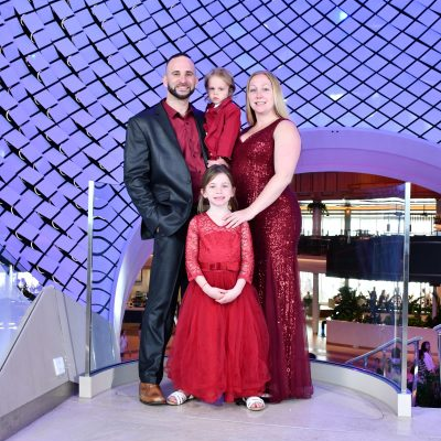A family is posing for a picture in front of a building.