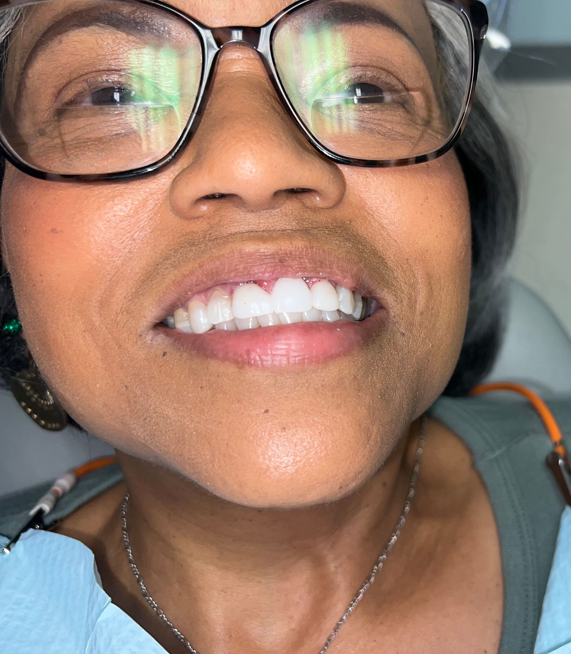 A close up of a woman wearing glasses and smiling