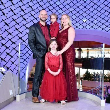 A family is posing for a picture in front of a building.
