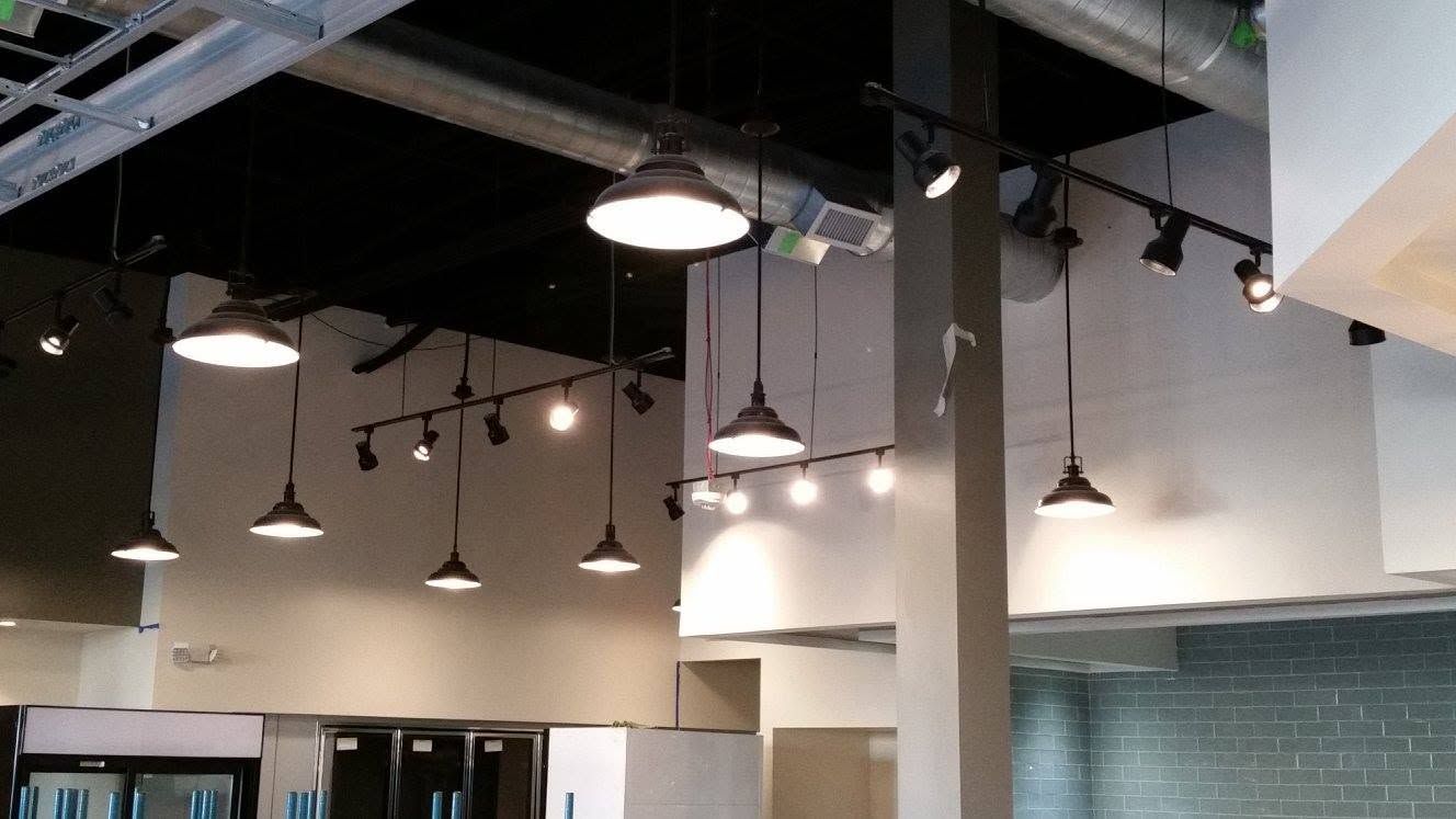 Industrial office ceiling with hanging pendant lights and exposed beams