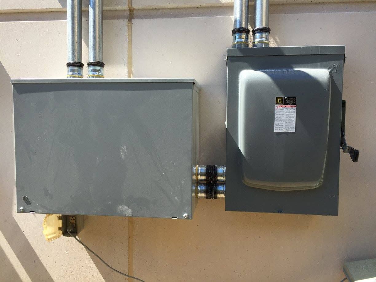 Electrical panels and conduit mounted on a wall in a utility area