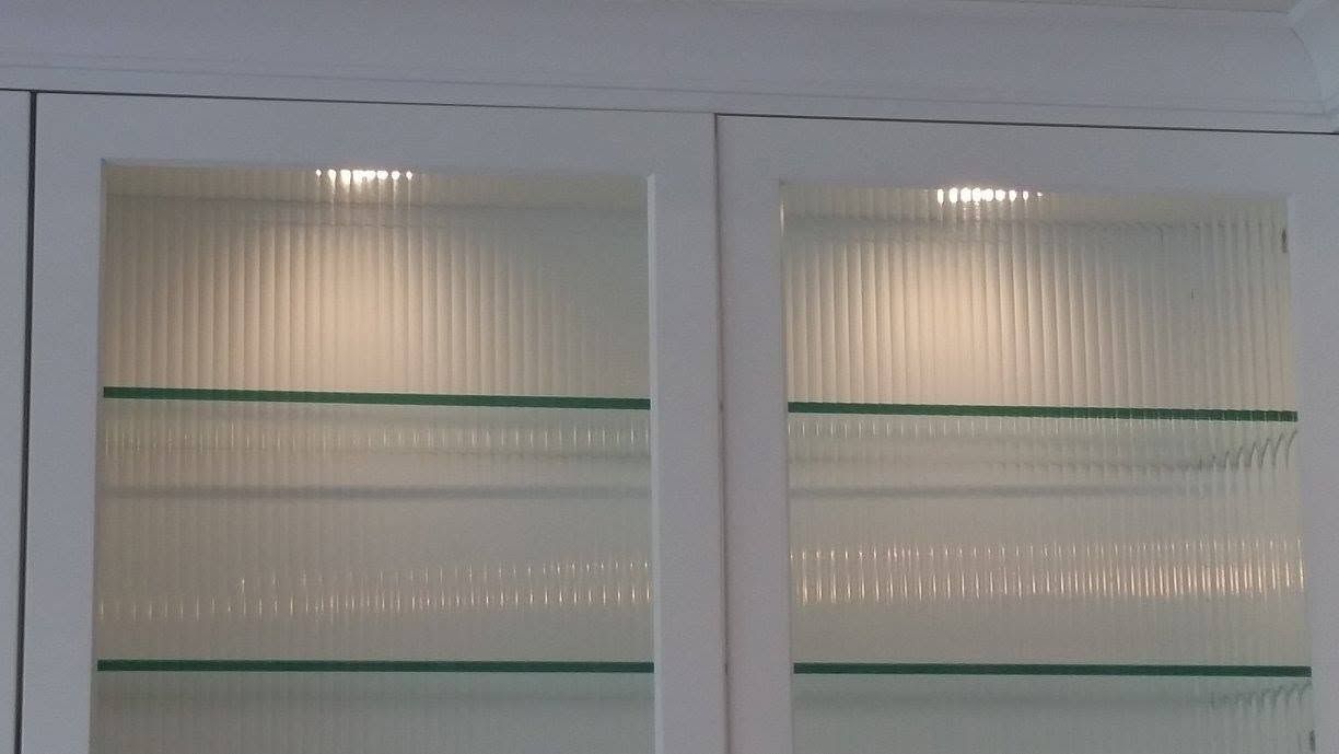 White cabinet with frosted glass doors and horizontal glass shelves.