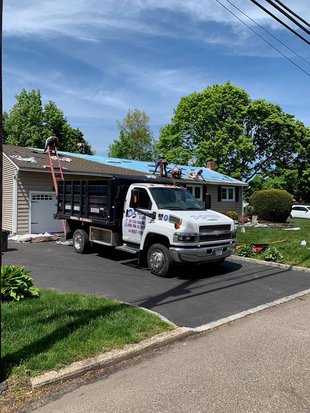 A dump truck is parked in front of a house.