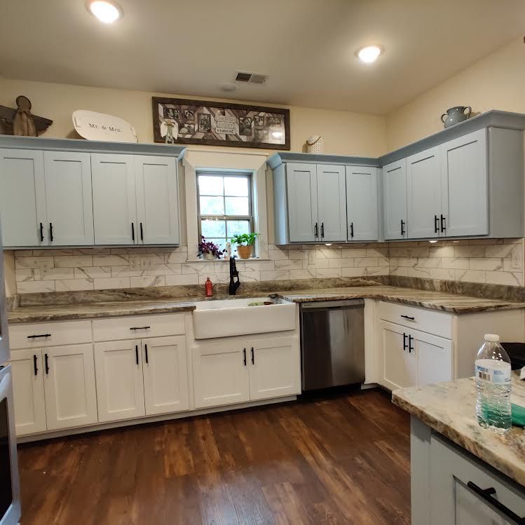 A kitchen with white cabinets and stainless steel appliances