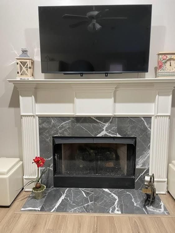 A living room with a fireplace and a flat screen tv.