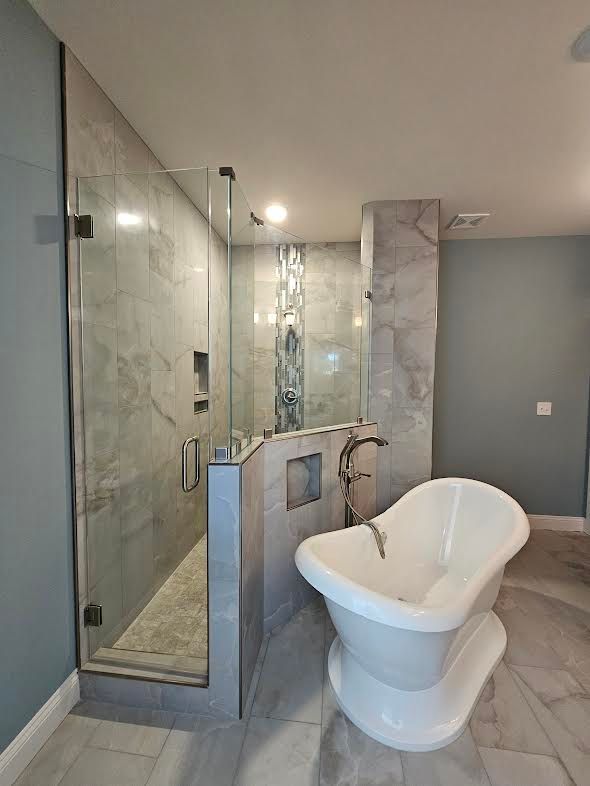 A bathroom with a bathtub and a walk in shower.