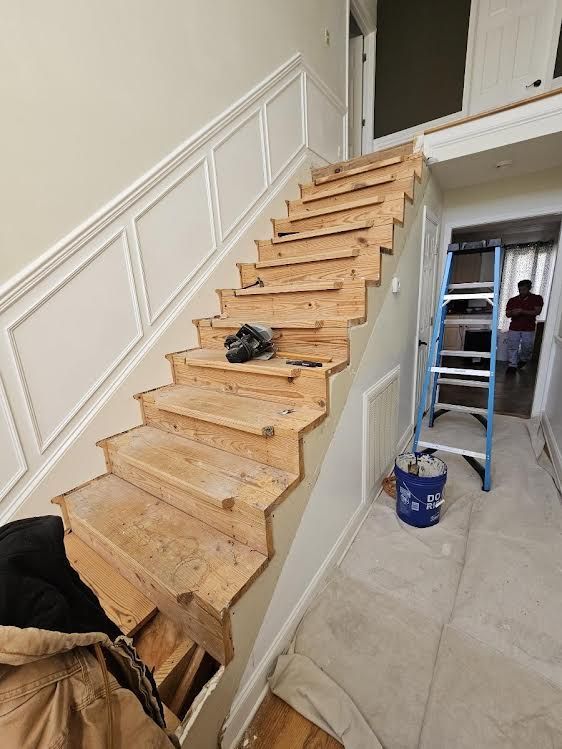 A wooden staircase is being built in a house.