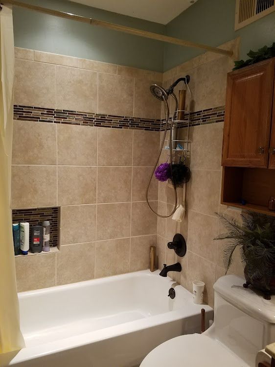 A bathroom with a tub , toilet and shower.