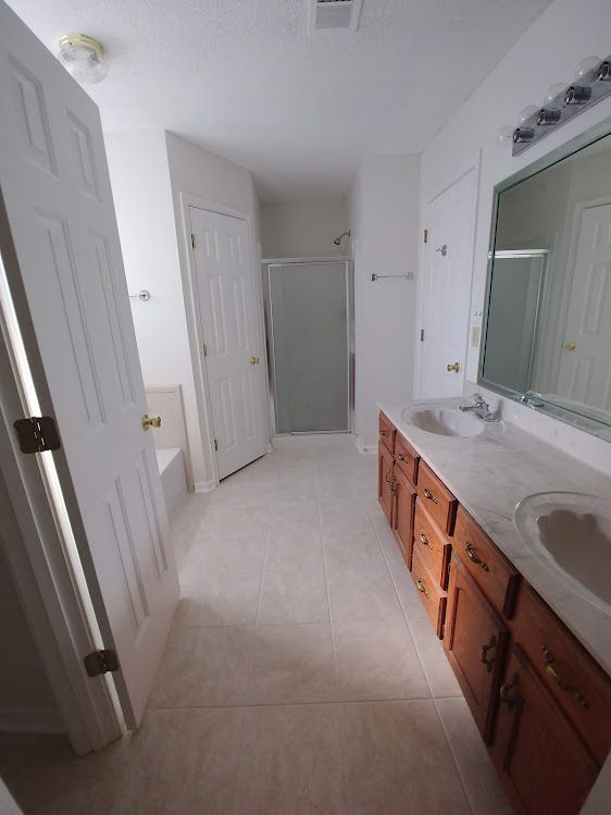 A bathroom with a sink , mirror and shower.