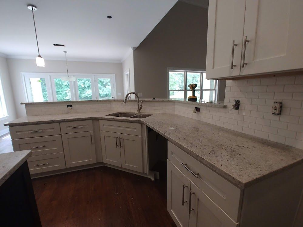 A kitchen with white cabinets and granite counter tops