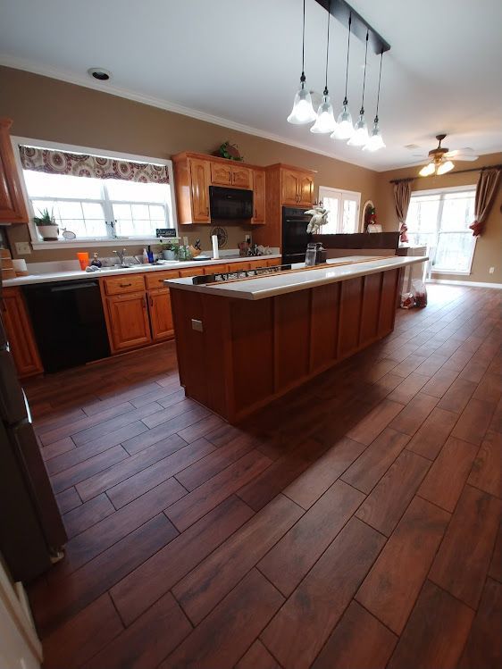 A kitchen with wooden cabinets and a large island