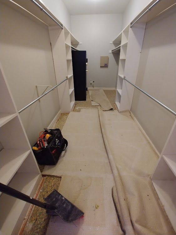 A walk in closet with a vacuum cleaner in it.