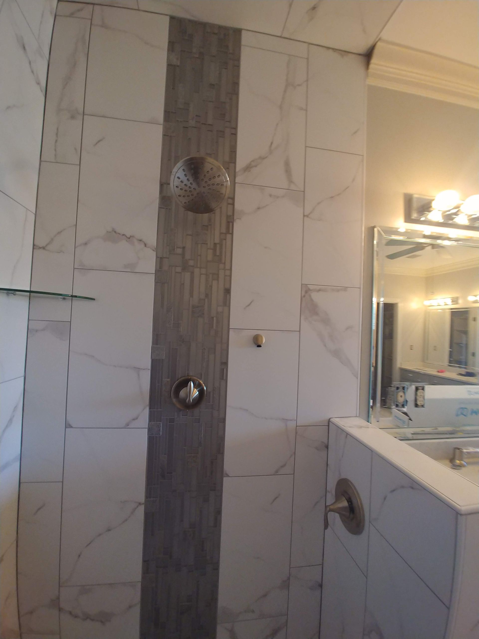A bathroom with a walk in shower and a mirror.