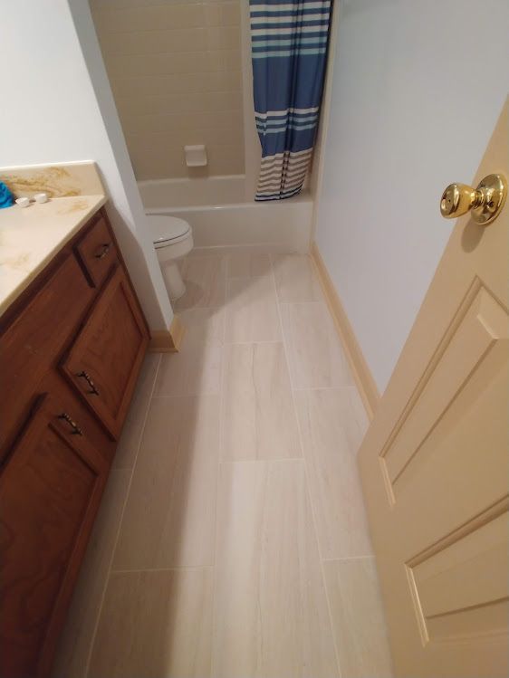 A bathroom with a toilet , sink , shower and bathtub.