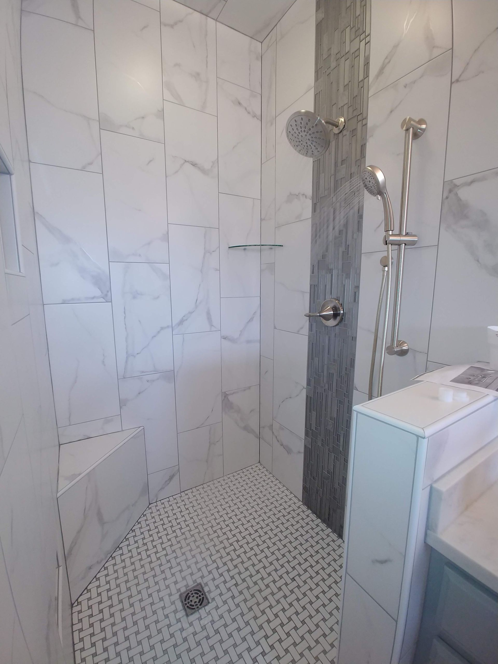 A bathroom with a walk in shower and a sink.