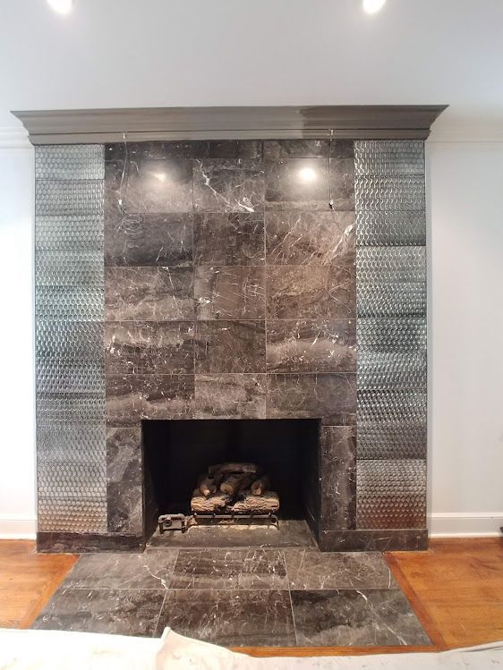 A fireplace with galss and stone tiles 
