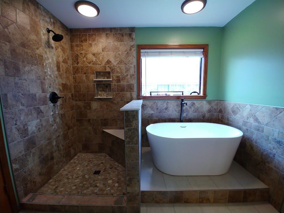 A bathroom with a tub , shower and window