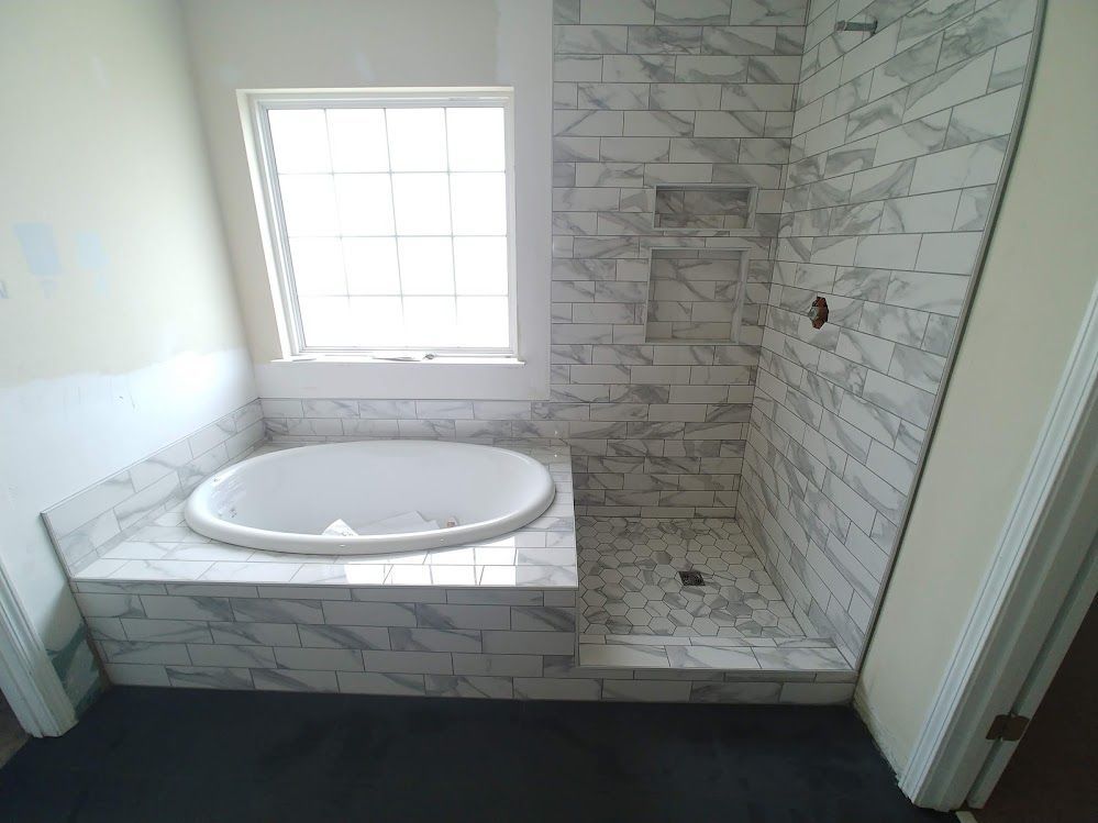 A bathroom with a jacuzzi tub and a walk in shower.