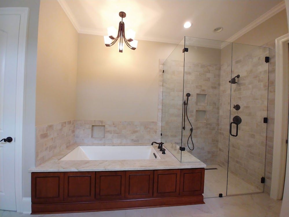 A bathroom with a bathtub and a walk in shower.