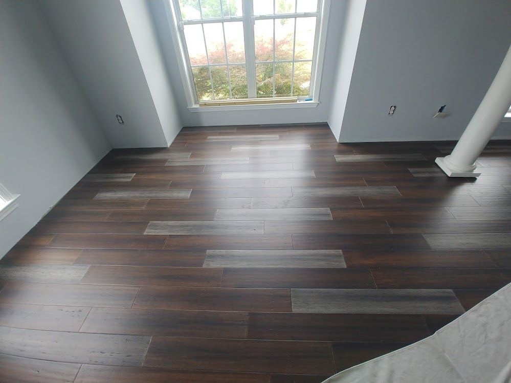 A room with a wooden floor and a window.