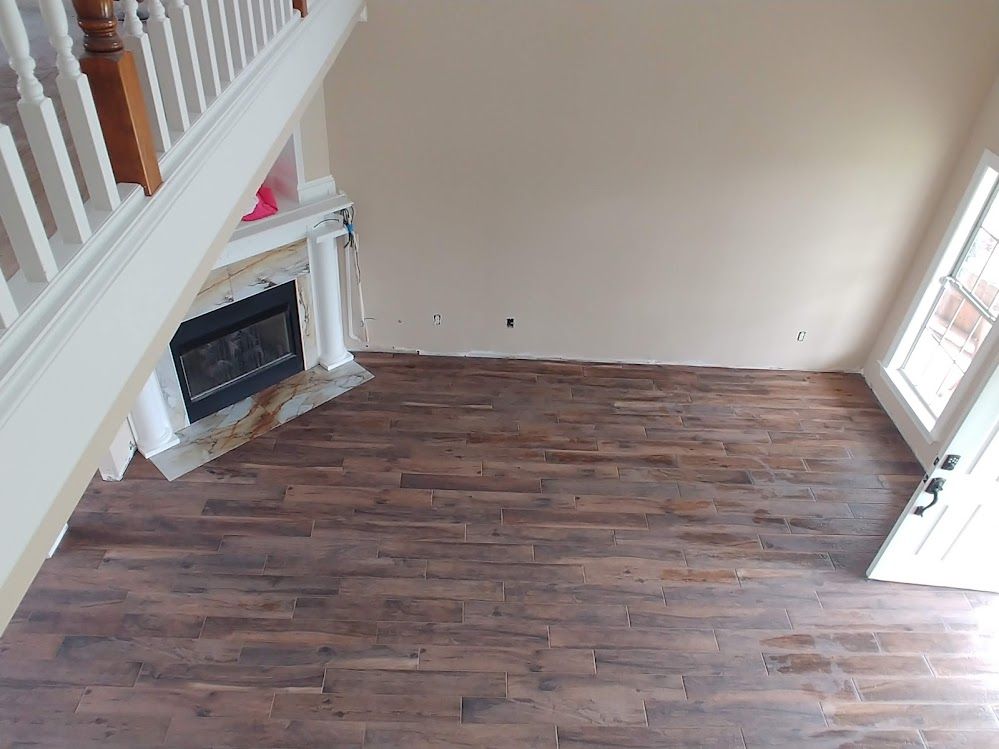 An aerial view of a living room with hardwood floors and a fireplace.