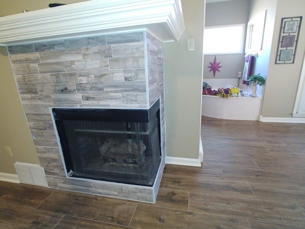 A fireplace in a living room next to a bathtub.