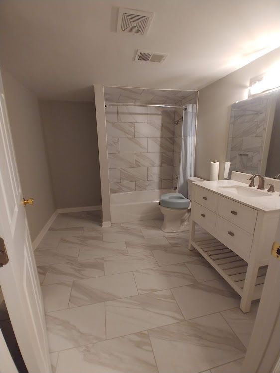 A bathroom with a sink , toilet , shower and bathtub.