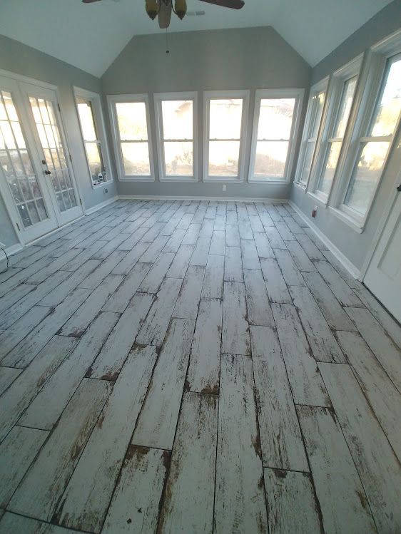 A room with a wooden floor and lots of windows