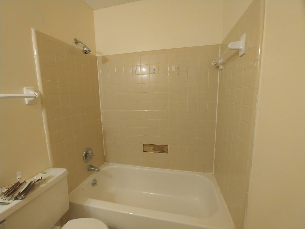 A bathroom with a toilet a bathtub and a shower